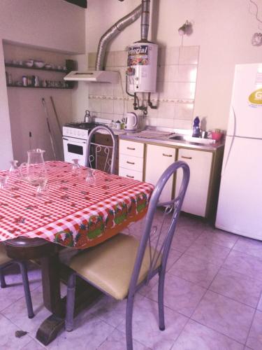 a kitchen with a table and a stove and a refrigerator at Hospedaje Violeta in Victoria