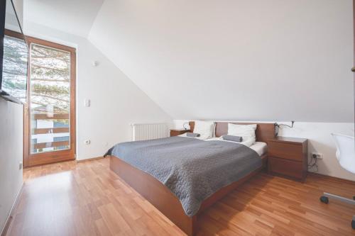 a bedroom with a bed and a large window at Panorama Buda in Budapest