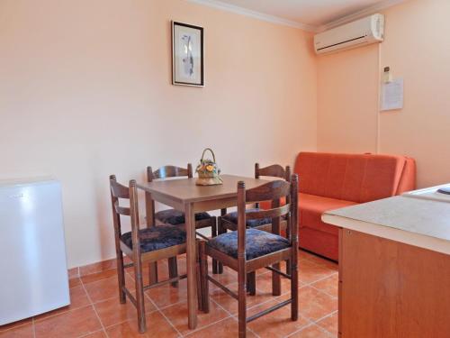 a kitchen with a table and chairs and a couch at Apartmani Sindik in Tivat