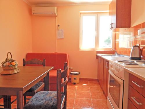 a kitchen with a wooden table and a table and a dining room at Apartmani Sindik in Tivat