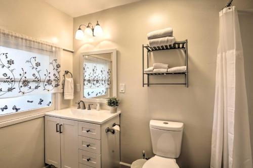 een badkamer met een toilet, een wastafel en een spiegel bij Chula Vista Retreat Near Third Avenue Village in Chula Vista