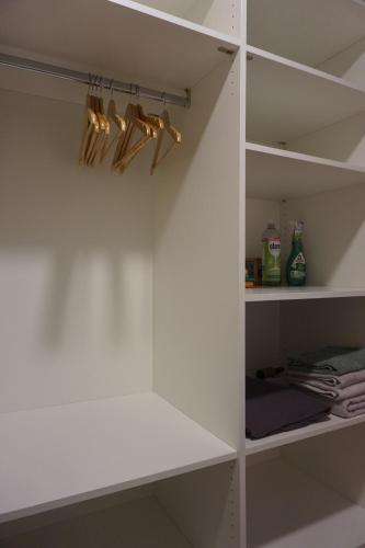 a closet with white walls and white shelves at Schönes Neubau Serviced-Apartment mit Parkplatz in Bruchsal