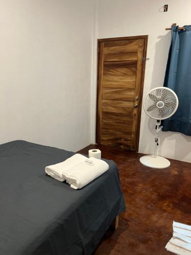 a room with a bed and a fan and a door at Cabañas las Palmas Chacahua in Yegüey