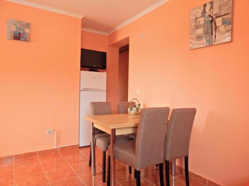 a dining room with a wooden table and chairs at Apartmani Sindik in Tivat