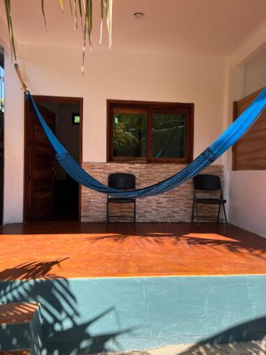 a hammock in a room with a pool at Cabañas las Palmas Chacahua 