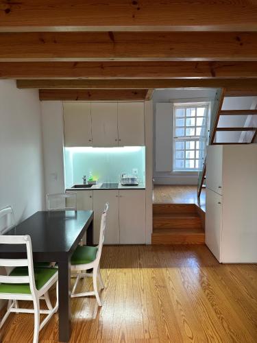 a kitchen and dining room with a table and chairs at Guimarães Studios Lounge in Guimarães