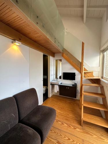 a living room with a couch and a staircase at Guimarães Studios Lounge in Guimarães