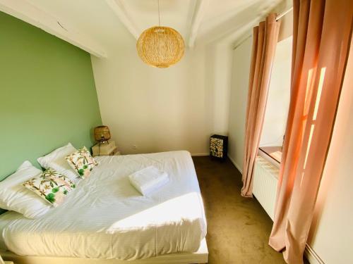 a bedroom with a white bed and a window at Les Villas du Domaine de Suzel in Vignieu