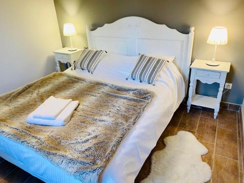a bedroom with a bed with two tables and a white bedspread at Les Villas du Domaine de Suzel in Vignieu