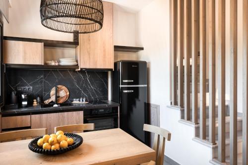 a kitchen with a wooden table and a black refrigerator at Sezian Boutique Homes and Villas in Preveza