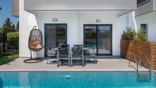 a patio with a table and chairs next to a pool at Sezian Boutique Homes and Villas in Preveza