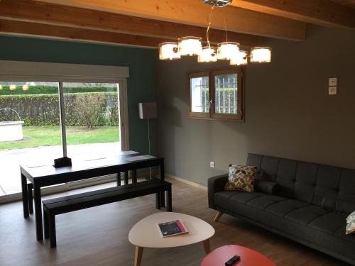 a living room with a couch and a piano at Les Villas du Domaine de Suzel in Vignieu