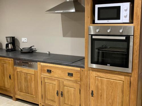a kitchen with a microwave on top of a counter at Les Villas du Domaine de Suzel in Vignieu