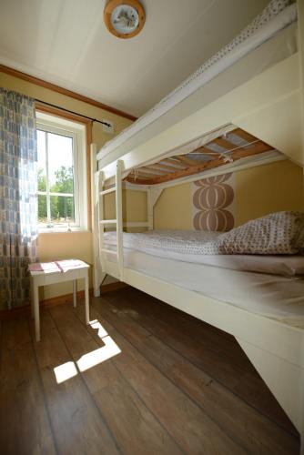 a bedroom with two bunk beds and a window at Wismens Natur & Fiske in Krogsered