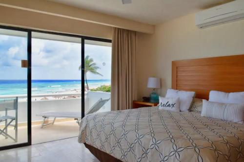 a bedroom with a bed and a view of the beach at Ocean front Villa in Cancun Hotel Zone in Cancún