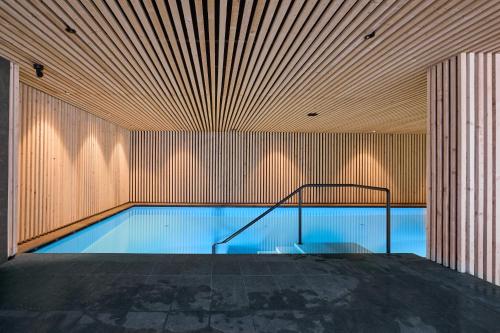 a swimming pool in a building with a wooden wall at Wellness-Sporthotel Ratschings in Racines