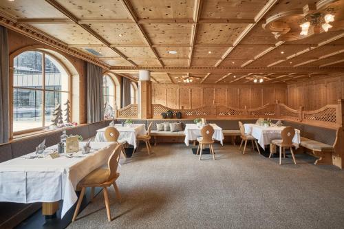 a dining room with white tables and chairs at Wellness-Sporthotel Ratschings in Racines