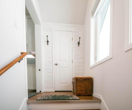 a hallway with a white door and a basket on the floor at Berg Haus by NW Comfy Cabins in Leavenworth