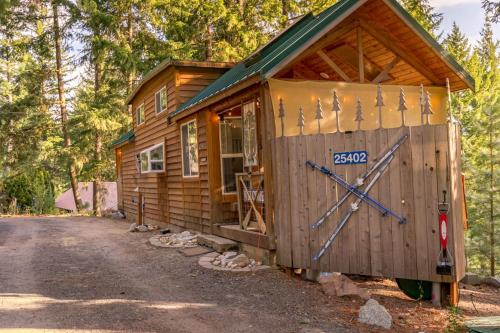 a wooden cabin with a large clock on the door at Das Tree Haus by NW Comfy Cabins in Leavenworth