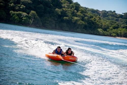 two people riding in an orange raft in the water at Dunama Hotel in Playa Flamingo