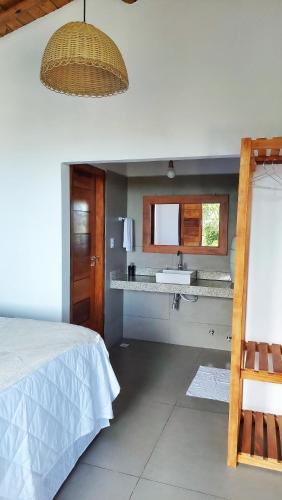 a bedroom with a bed and a sink in it at Aldeia Biribiri - Pousada in Caraíva