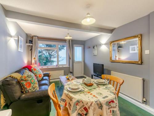 a living room with a table and a couch at Sand Bar - Mount Brioni in Downderry