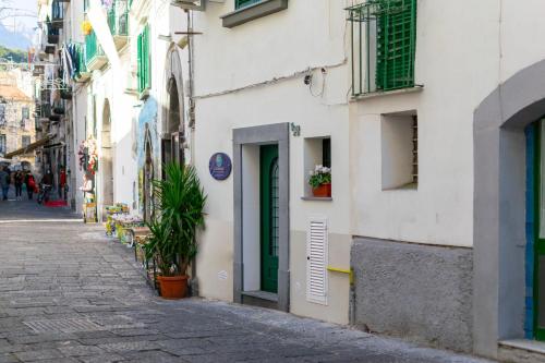 una calle estrecha con un edificio blanco con una puerta verde en Casagiugiù en Vietri