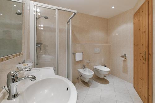a bathroom with a shower and a sink and a toilet at Wellness-Sporthotel Ratschings in Racines