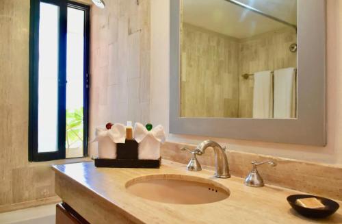 a bathroom with a sink and a mirror at Ocean front Villa in Cancun Hotel Zone in Cancún