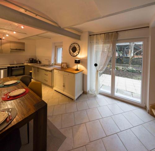 a large kitchen with a table and a large window at La grange de Sophie in Berstett