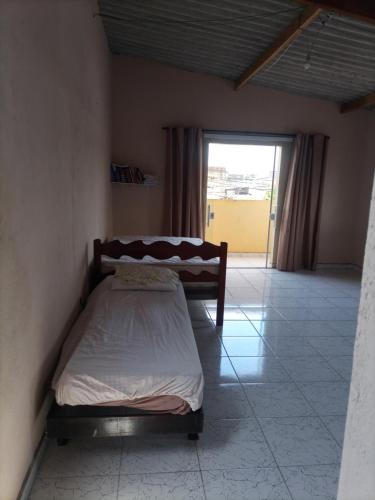 1 dormitorio con 1 cama en una habitación con ventana en Recanto da Paz en Solemar