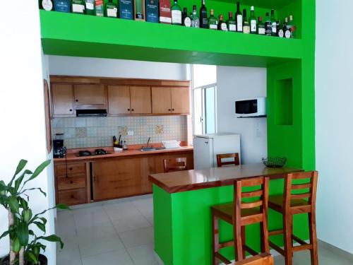 a green kitchen with wooden cabinets and a green shelf at Hotel La Estrella Polar in Costa Esmeralda