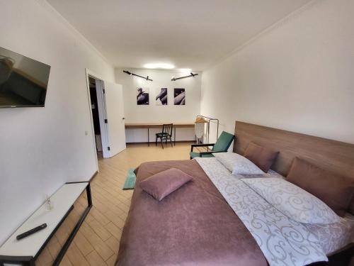 ein Schlafzimmer mit einem großen Bett und einem Schreibtisch in der Unterkunft Like Home on Mikhnovskogo in Iwano-Frankiwsk