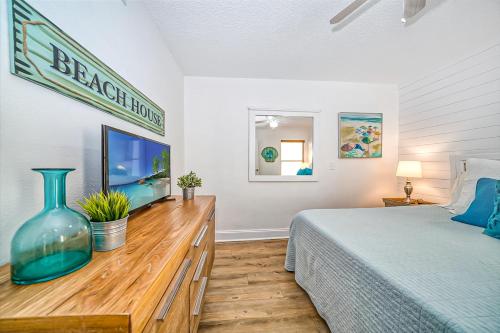 een slaapkamer met een bed en een televisie op een houten dressoir bij Belleair Beach Club 212 in Clearwater Beach