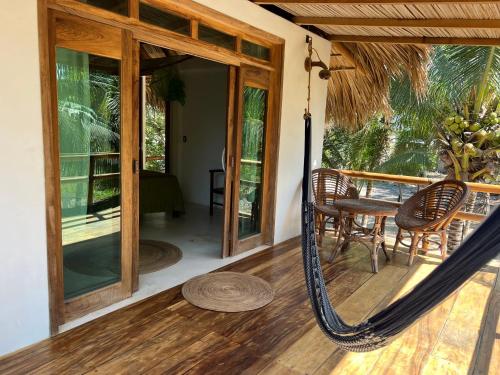 a hammock on the front porch of a house at Cabañas las Palmas Chacahua in Yegüey