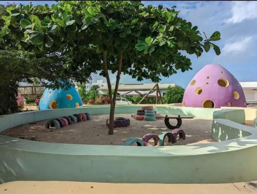 a playground with a tree and colorful structures at Modern Apartment - Work from Zanzibar (Fumba Town) in Dambani