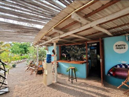 a building with awning and a bar with chairs and tables at Modern Apartment - Work from Zanzibar (Fumba Town) in Dambani