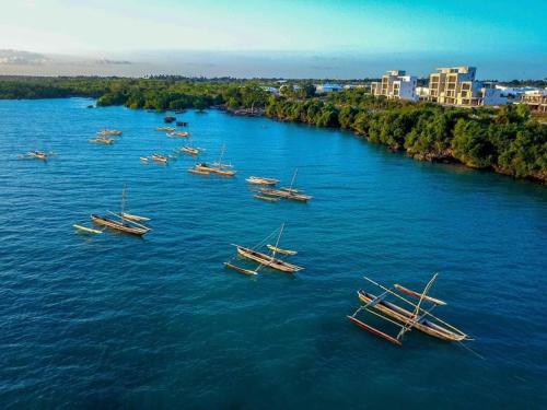 a group of boats sitting in the water at Modern Apartment - Work from Zanzibar (Fumba Town) in Dambani