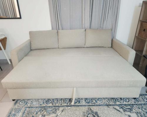 a couch sitting in a living room at Modern Apartment - Work from Zanzibar (Fumba Town) in Dambani