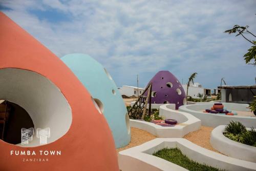 a playground with colorful structures in a park at Modern Apartment - Work from Zanzibar (Fumba Town) in Dambani
