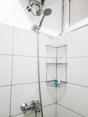 a shower with a hose hanging from the wall at Modern Apartment - Work from Zanzibar (Fumba Town) in Dambani