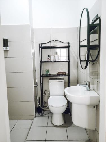 a bathroom with a toilet and a sink at Modern Apartment - Work from Zanzibar (Fumba Town) in Dambani