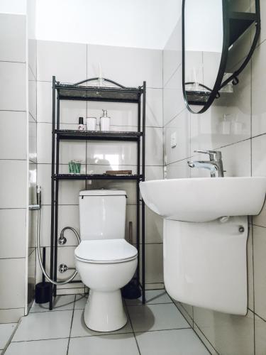 a bathroom with a white toilet and a sink at Modern Apartment - Work from Zanzibar (Fumba Town) in Dambani