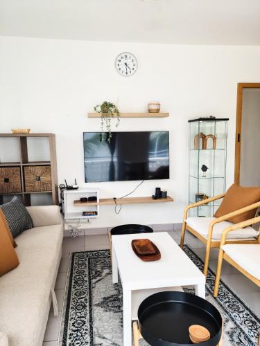 a living room with a couch and a tv at Modern Apartment - Work from Zanzibar (Fumba Town) in Dambani
