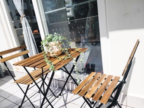 a wooden table with a potted plant and two chairs at Modern Apartment - Work from Zanzibar (Fumba Town) in Dambani