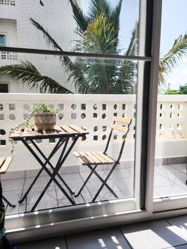 a table and chairs on a balcony with a window at Modern Apartment - Work from Zanzibar (Fumba Town) in Dambani