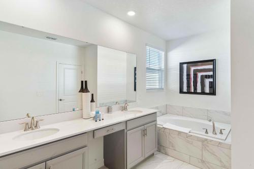 a white bathroom with two sinks and a tub at 9203 Sommerset Hills Drive in Kissimmee