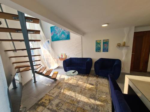 a living room with two blue chairs and a staircase at Dolce Vita Palacio in Douala