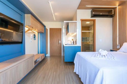 - une chambre avec un lit blanc et un mur bleu dans l'établissement Mana Beach Experience Muro Alto por Brevelar, à Porto de Galinhas