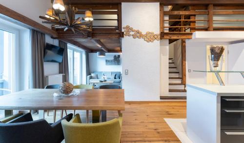 a kitchen and dining room with a table and chairs at Hotel Residenz Hochalm - Joker Card Partner in Saalbach Hinterglemm